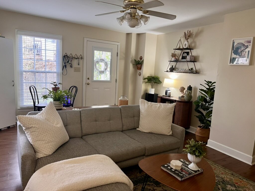 Furnished 1023 living room with gray sectional, looking toward the front door and covered porch